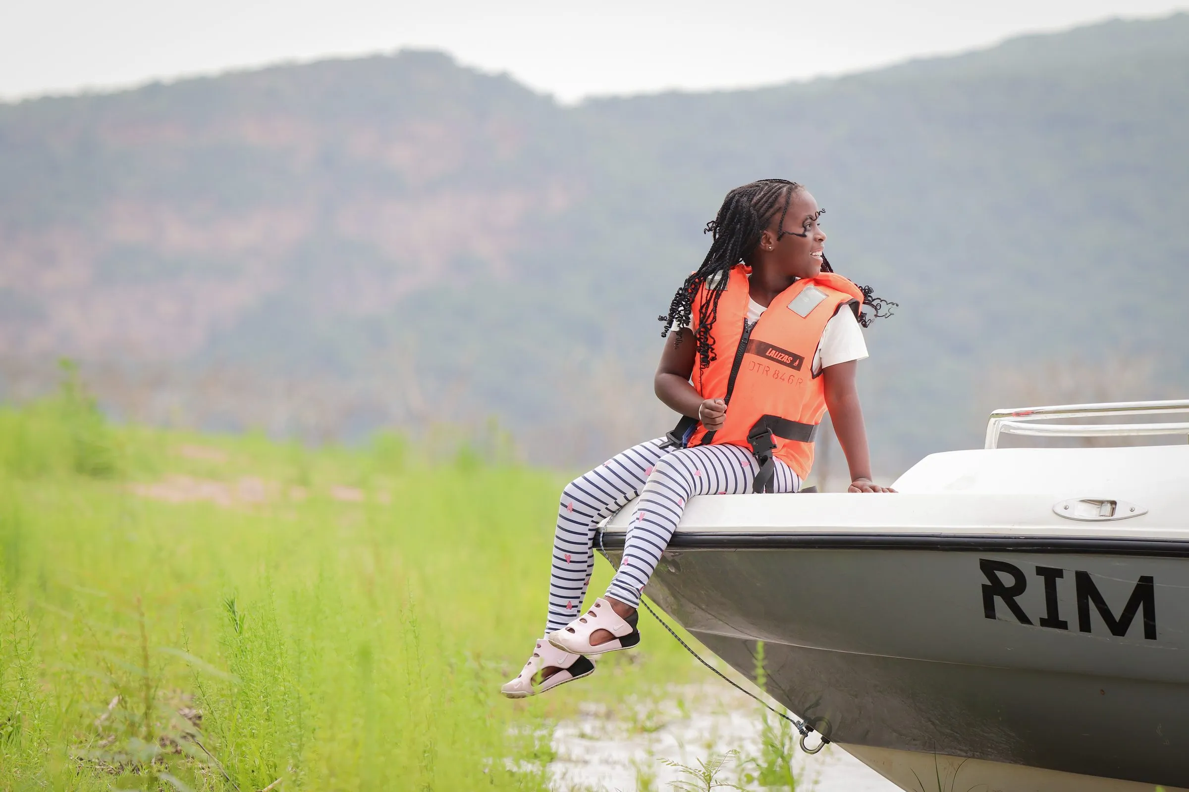 Guest in a life jacket on the boat near the shore