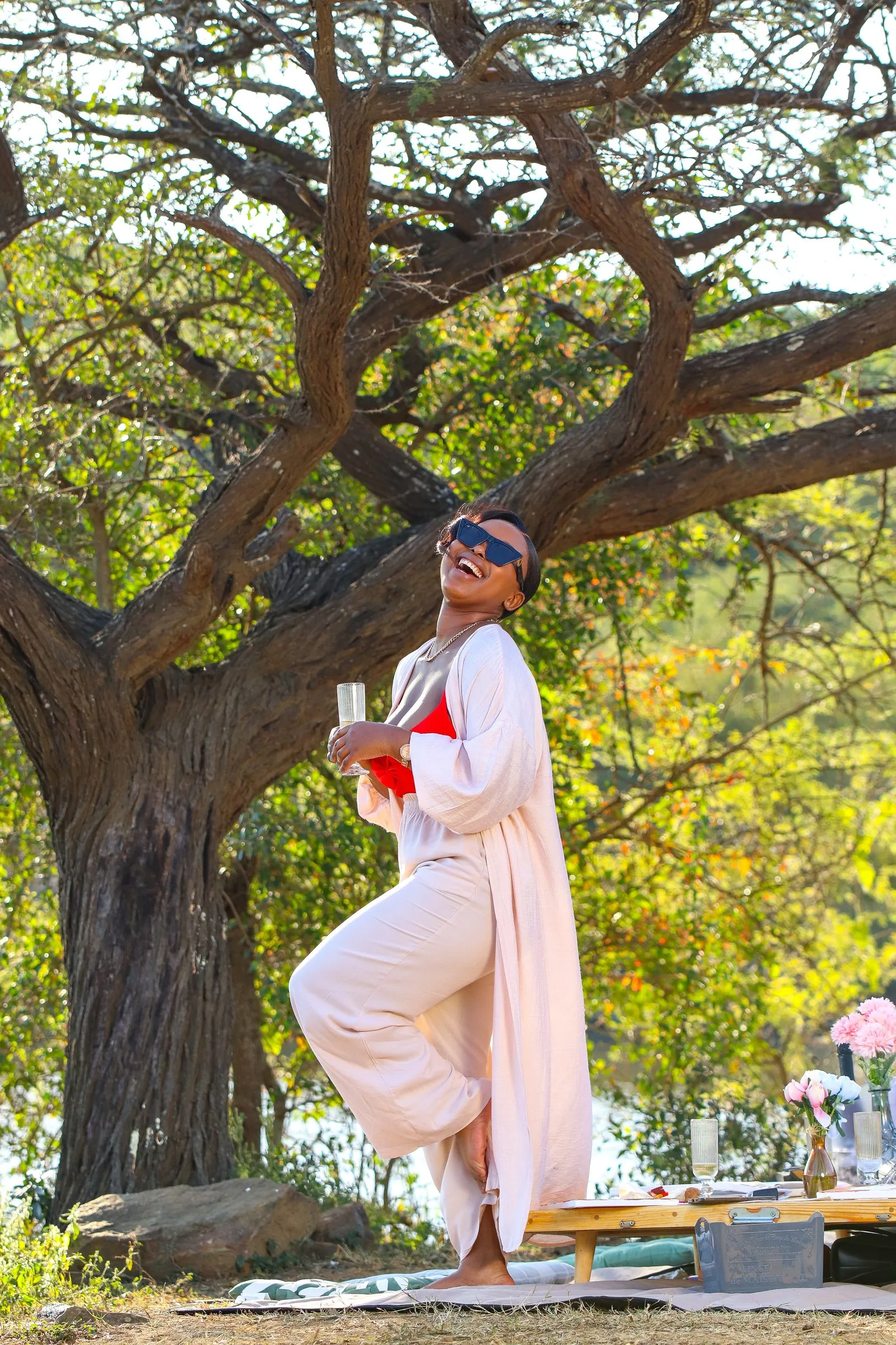 Guest standing under a large tree beside the dam