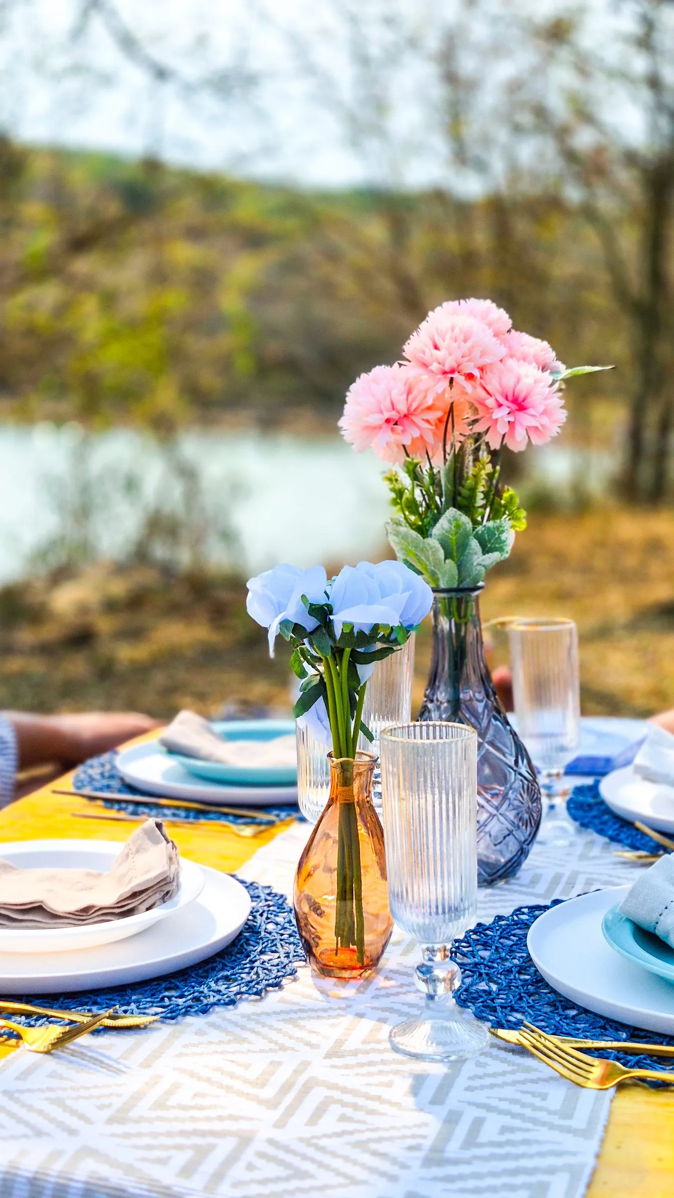 Picnic table set with plates and flowers