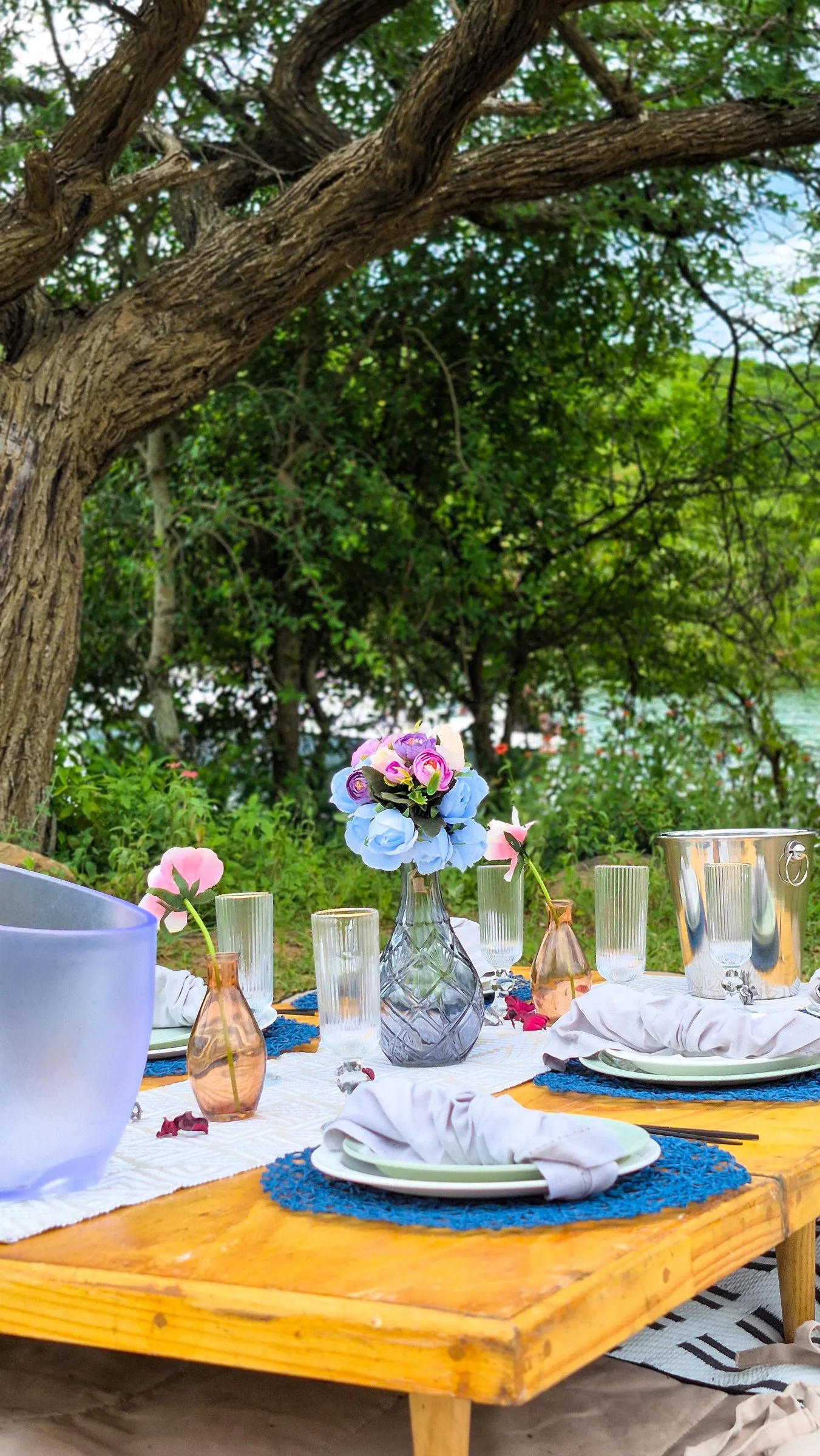 Picnic table with vases of flowers and place settings