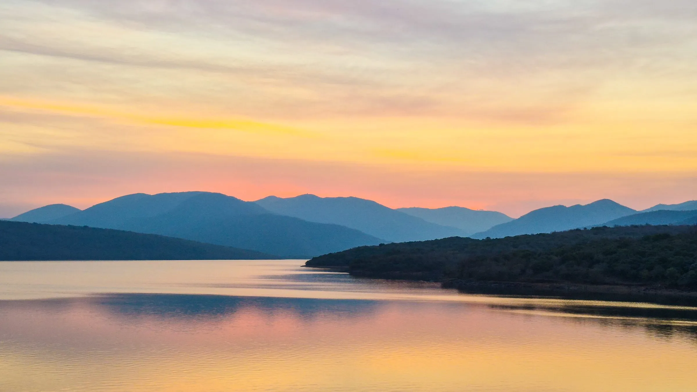 Golden sunset over the still water of Phobane Dam